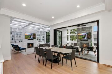 A luxury dining area in front of a large open glass door of a custom modern home.