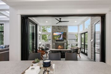 View from the dining area looking out at a large open glass door peering into a indoor patio.