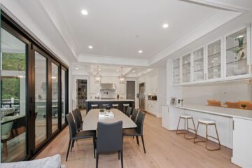 A luxury dining area next to a kitchen in a custom modern home.