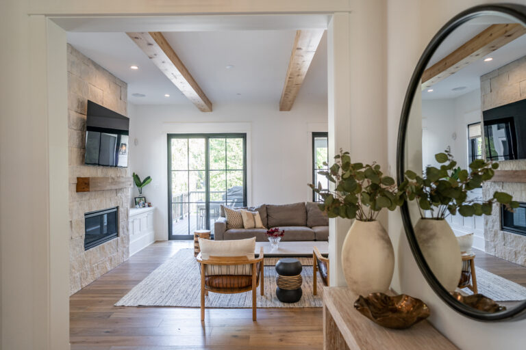 A modern home entryway looking into a living room designed with natural organic accents.